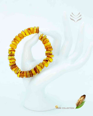 Yellow amber bracelet on a hand-shaped stand.