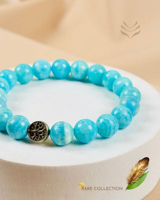 Light-coded hemimorphite bracelet with tree charm on display.