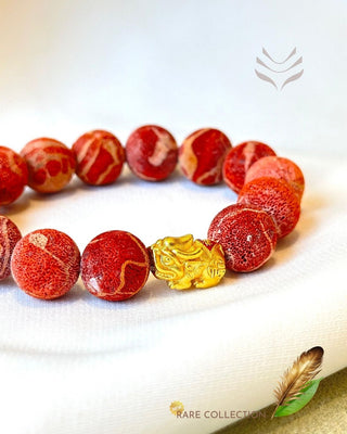 Coral Bead Bracelet featuring intricate gold charm