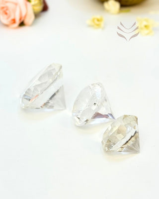 Three clear quartz diamonds on a white surface