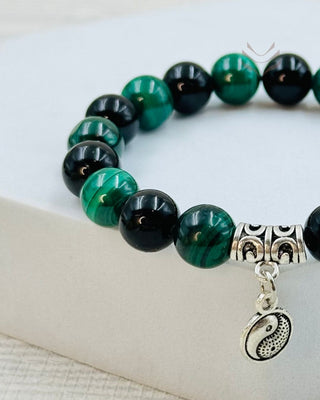 Close-up of crystal bracelet featuring yin-yang charm.