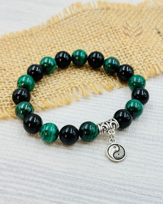 Karmic pattern release bracelet with green and black beads.