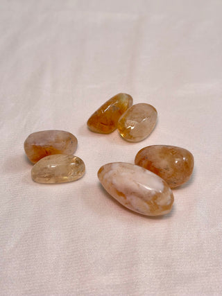 Collection of polished citrine tumbles on fabric